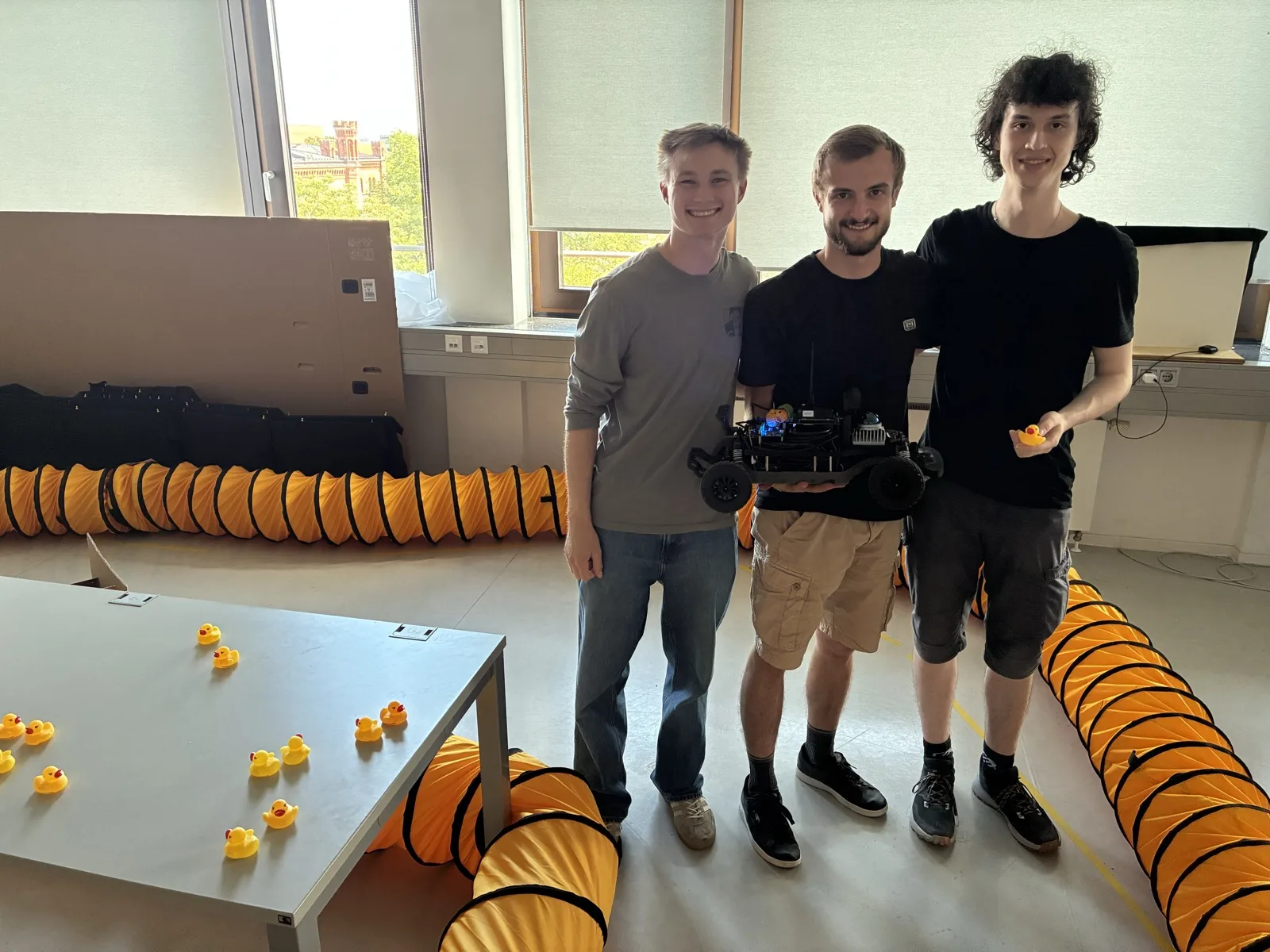 A student team holding their robot car