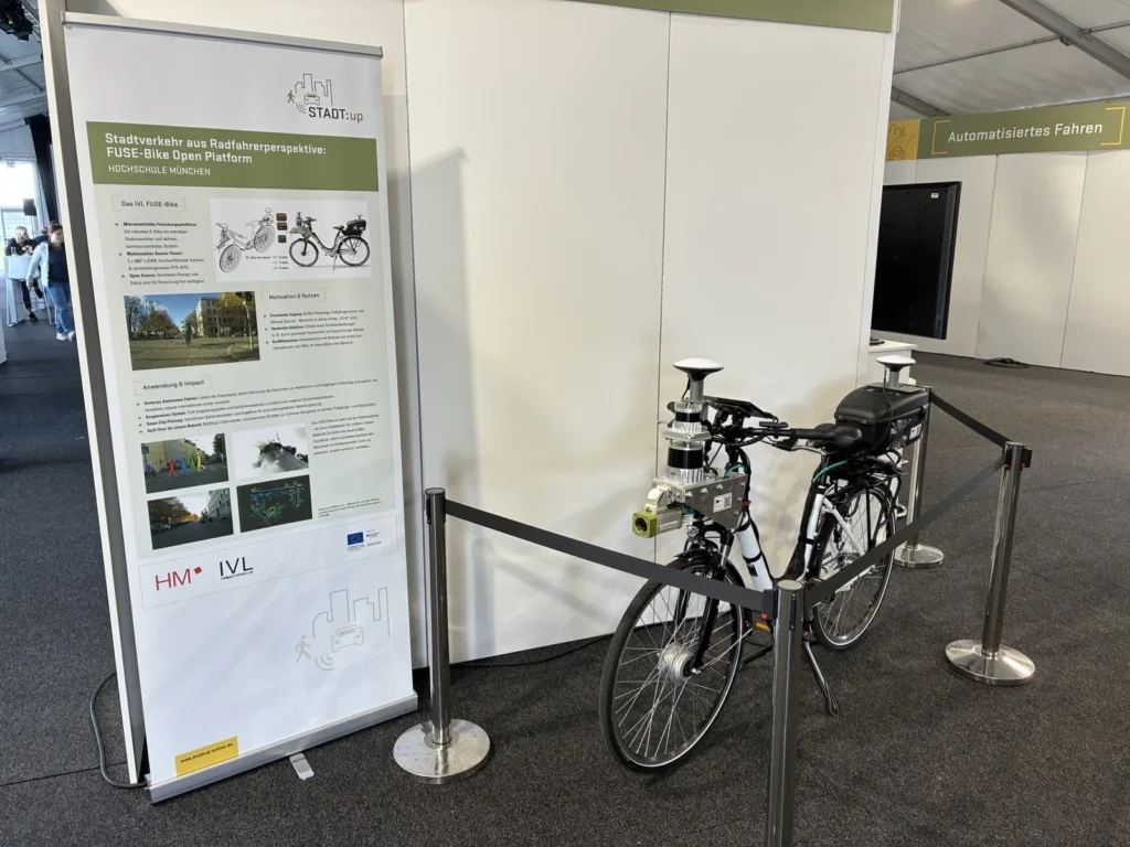 Demonstration stand with the instrumented bicycle and the project poster